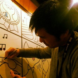 Susumu Kimura (TTB Editor) tattooing a cat at the GenArt event